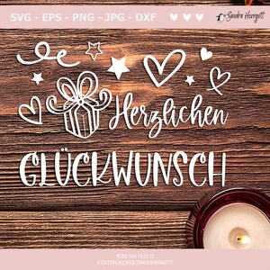 May include: White text on a wood background that reads "Herzlichen Gl&uuml;ckwunsch" with a gift box, stars, and hearts surrounding the text.