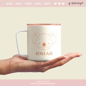 K&ouml;nnte beinhalten: Eine wei&szlig;e Tasse mit kupferfarbenem Rand und wei&szlig;em Henkel. Die Tasse zeigt eine Cartoon-Koala-Illustration und den Namen "JOSIAH" in einer passenden Farbe. Das Bild enth&auml;lt auch Text zu SVG-Dateien und dem Etsy-Shop.