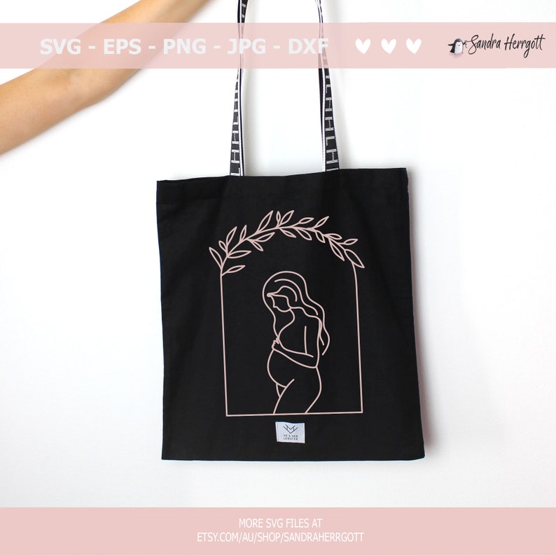 Pu&ograve; includere: Una borsa tote nera con un contorno rosa di una donna incinta in piedi in un arco floreale. Il testo "MORE SVG FILES AT ETSY.COM/AU/SHOP/SANDRAHERRGOTT" &egrave; stampato sul fondo della borsa.