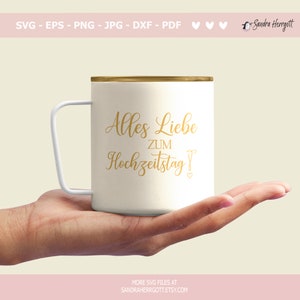 May include: A white mug with a gold rim and handle, inscribed with gold script reading "Alles Liebe ZUM Hochzeitstag!" The mug is held in a hand. The image also includes the designer's name and file type options.