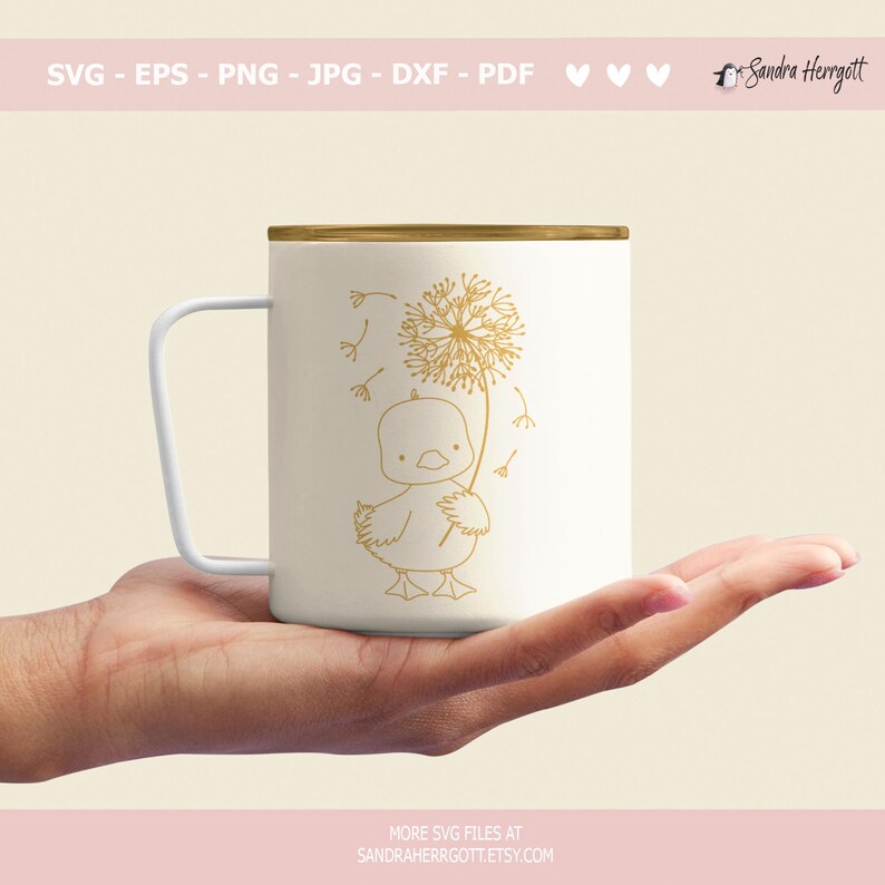 May include: A white mug with a gold outline of a duckling holding a dandelion. The dandelion has seeds blowing in the wind.