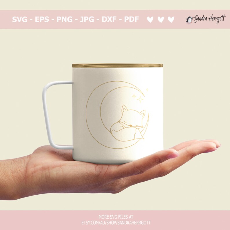 May include: White ceramic mug with a gold outline of a crescent moon and a sleeping fox inside the moon. The mug has a gold rim and a handle.