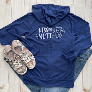 May include: A navy blue long-sleeved hoodie with a white graphic on the back that says "Kiss my Mutt" with a cartoon dog's head next to it.