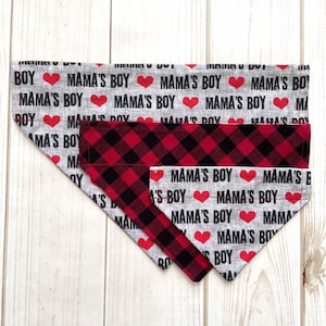 May include: Two dog bandanas, one red and black plaid and one gray with the text "Mama's Boy" repeated and red hearts.