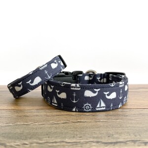 May include: Two navy blue dog collars with a white whale, anchor, sailboat, and ship's wheel pattern.