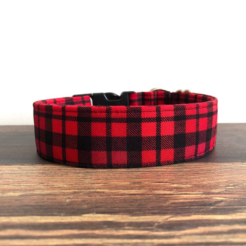 May include: Red and black checked dog collar with a black plastic buckle.