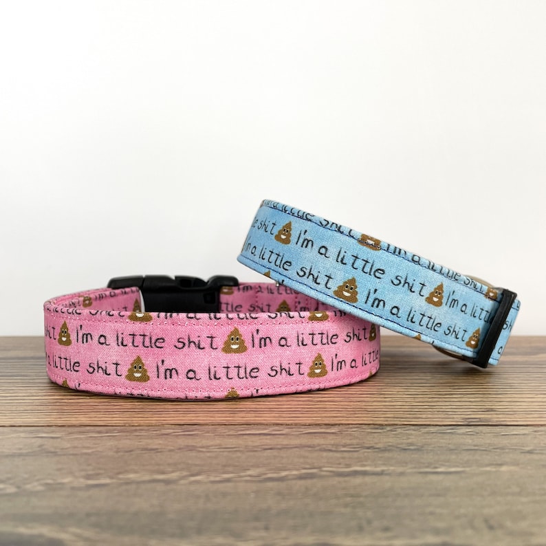 May include: Two dog collars, one pink and one light blue, with a repeating pattern of a poop emoji and the text "I'm a little shit".