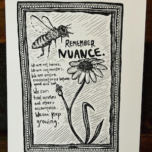 Op de afbeelding: Zwart-witte illustratie van een bij, een bloem en tekst die luidt "Remember Nuance. We are not heroes. We are not monsters. We are entire constellations between good and bad. We can hold ourselves and others accountable. We can keep growing."