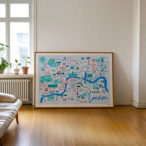 May include: A framed illustration of a map of London, England. The map is drawn in a colorful, whimsical style and features landmarks like Buckingham Palace, the London Eye, and the Houses of Parliament. The text "London" is written in a large, stylized font at the bottom of the map.