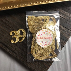 May include: Gold glitter number 39 confetti in a clear plastic bag with a white label that says "The Fetti Boutique Balloons and Party Decor".