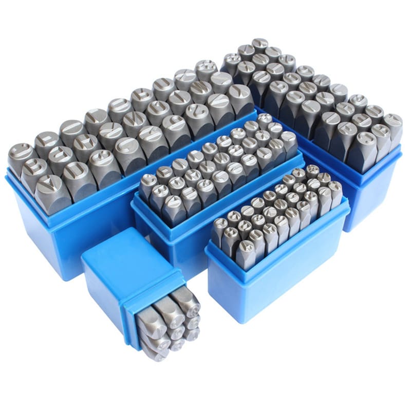 May include: A set of metal letter stamps in various sizes, neatly organized in blue plastic storage boxes. The stamps are gray and feature different letter designs for crafting or marking.