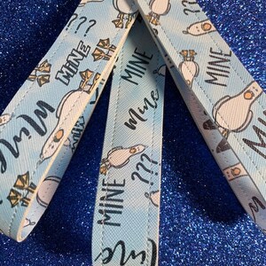 May include: Three blue and white fabric keychains with a seagull design and the text "Mine" and "Mine Mine" repeated on each keychain.