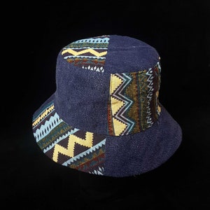 May include: A blue bucket hat with a geometric pattern in shades of yellow, blue, green, and brown.