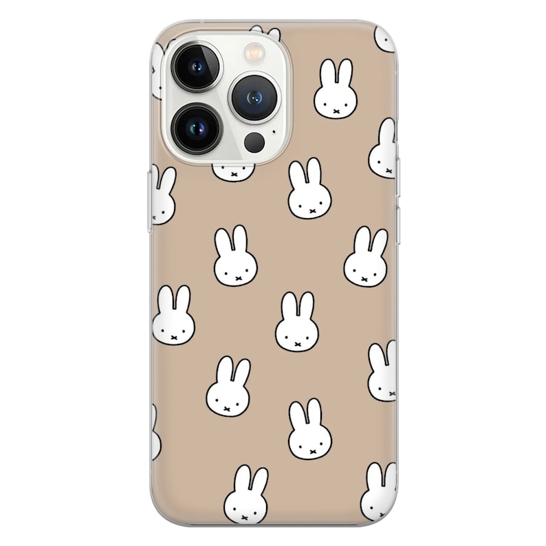 May include: A clear phone case with a beige background and a repeating pattern of white bunny rabbit faces.