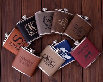 May include: Eight personalized leather-wrapped stainless steel hip flasks with various engraved designs and names. The flasks are arranged in a circle on a wooden surface.
