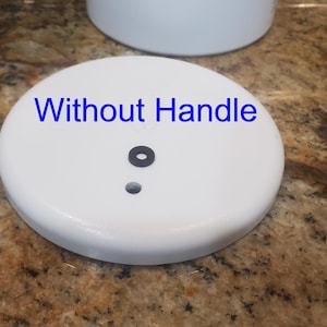 May include: White ceramic lid with a black rubber seal and a small hole in the center. The text "Without Handle" is written on the lid.