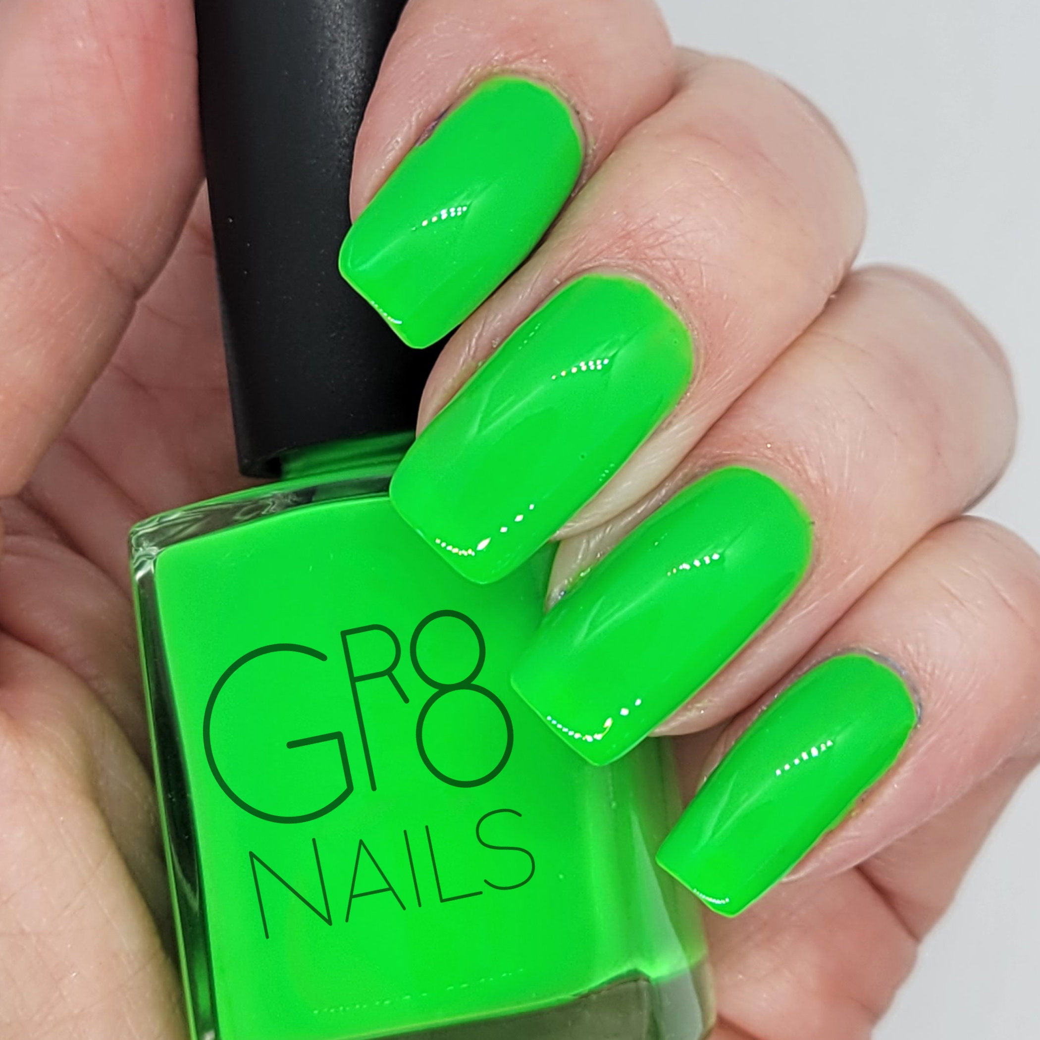 Female hand with long nails and neon green manicure with bottles of nail  polish Stock Photo | Adobe Stock