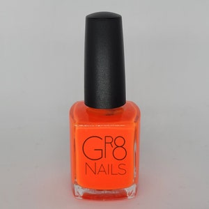 May include: A bottle of bright orange nail polish with a black cap. The bottle is square with rounded edges and features the text "GR8 NAILS" in black. The nail polish is a vibrant, solid color.