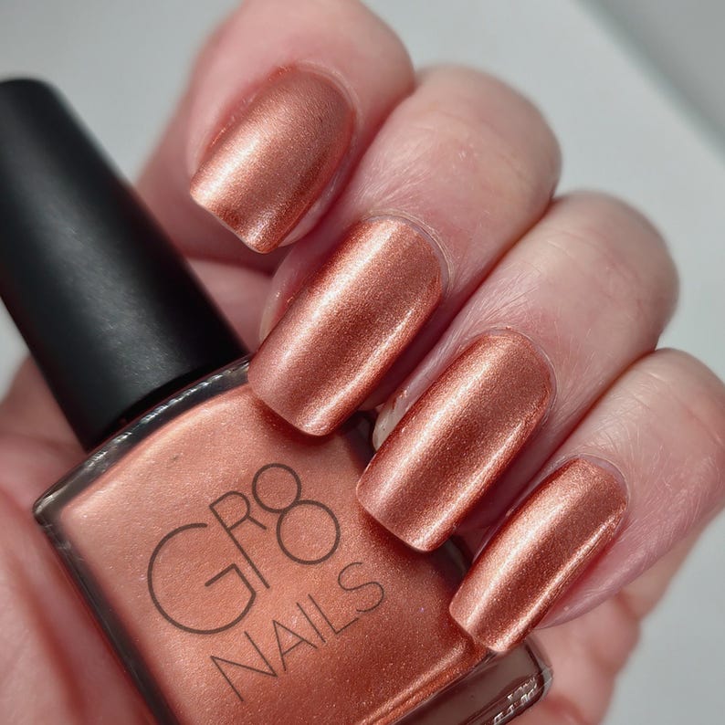 May include: A bottle of copper colored nail polish with the brand name 'GR8 NAILS' on the label.