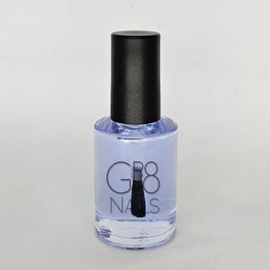 May include: A clear nail polish bottle with a black cap. The bottle contains a pale blue liquid and has the text "GR8 NAILS" printed on the front. The applicator brush is visible inside the bottle.