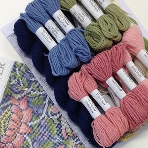 May include: A set of embroidery floss in various colors, including blue, green, pink, and navy. The floss is wrapped around white cardboard spools with the text "APPLETONS WOOL LTD" printed on them.