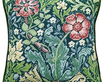 Op de afbeelding: Een groen, rood en wit kussen met een bloemenpatroon op een donkergroene achtergrond. Het kussen is gemaakt van een zachte, geweven stof en heeft een vierkante vorm.
