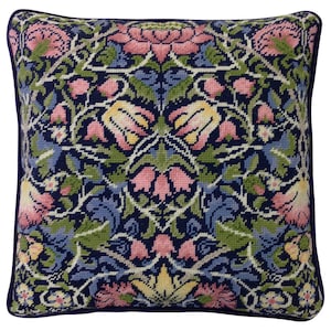 May include: A square pillow with a floral pattern in shades of pink, yellow, green, and blue on a dark blue background. The pillow has a dark blue border.