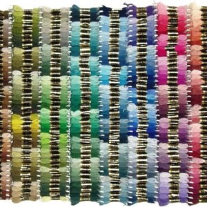 Puede incluir: Una vibrante exhibici&oacute;n de hilo de bordar en una amplia gama de colores. Los hilos est&aacute;n dispuestos en filas verticales, mostrando un degradado de tonos que van desde naranjas y amarillos c&aacute;lidos hasta azules y verdes fr&iacute;os, y terminando con rosas y rojos. Cada color est&aacute; cuidadosamente organizado.