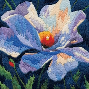 May include: A close-up of a needlepoint flower with blue, purple, white, and orange petals. The centre of the flower is a vibrant red and yellow. Green leaves and a red bud are visible in the background.