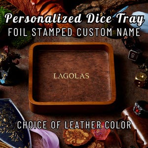 May include: A wooden dice tray with a brown leather interior. The tray has the name "LAGOLAS" foil stamped in gold. The text "Personalised Dice Tray" and "Choice of Leather Colour" are also visible.