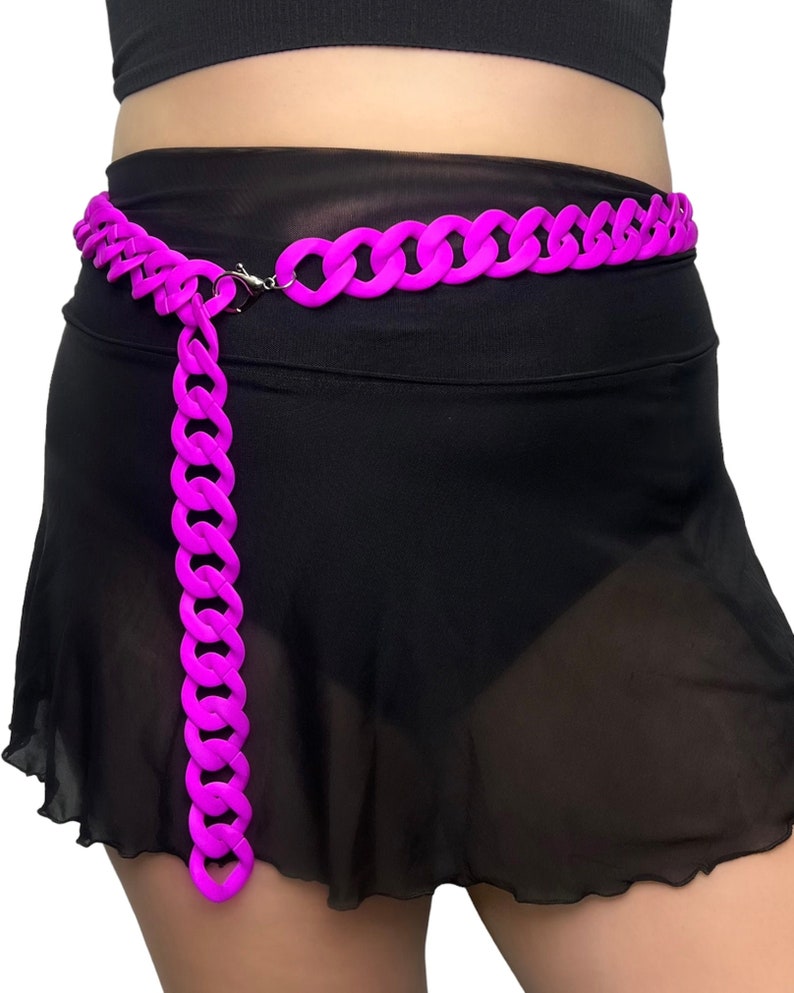 The model showcases a Colored Chunky Chain Belt in neon purple, adding a stylish touch to her festival outfit.