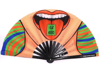 May include: A pop art style fan featuring a mouth with red lips and a tongue with the text "I EAT ASSID". The fan has orange, green, and blue striped accents and the text "ONE STOP RAVE".