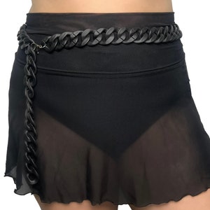 The model showcases a Colored Chunky Chain Belt in black, adding a stylish touch to her festival outfit.