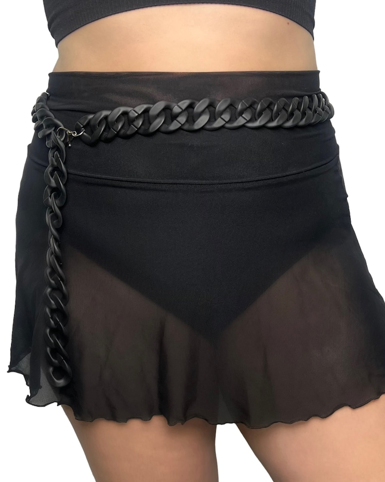 The model showcases a Colored Chunky Chain Belt in black, adding a stylish touch to her festival outfit.