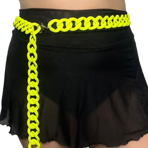 The model showcases a Colored Chunky Chain Belt in neon yellow, adding a stylish touch to her festival outfit.