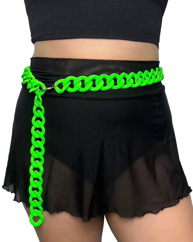 The model showcases a Colored Chunky Chain Belt in neon green, adding a stylish touch to her festival outfit.