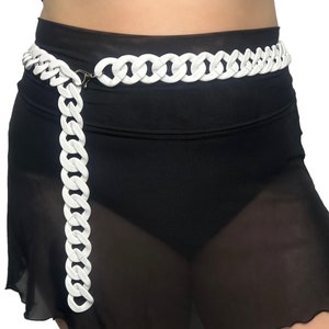 The model showcases a Colored Chunky Chain Belt in white, adding a stylish touch to her festival outfit.