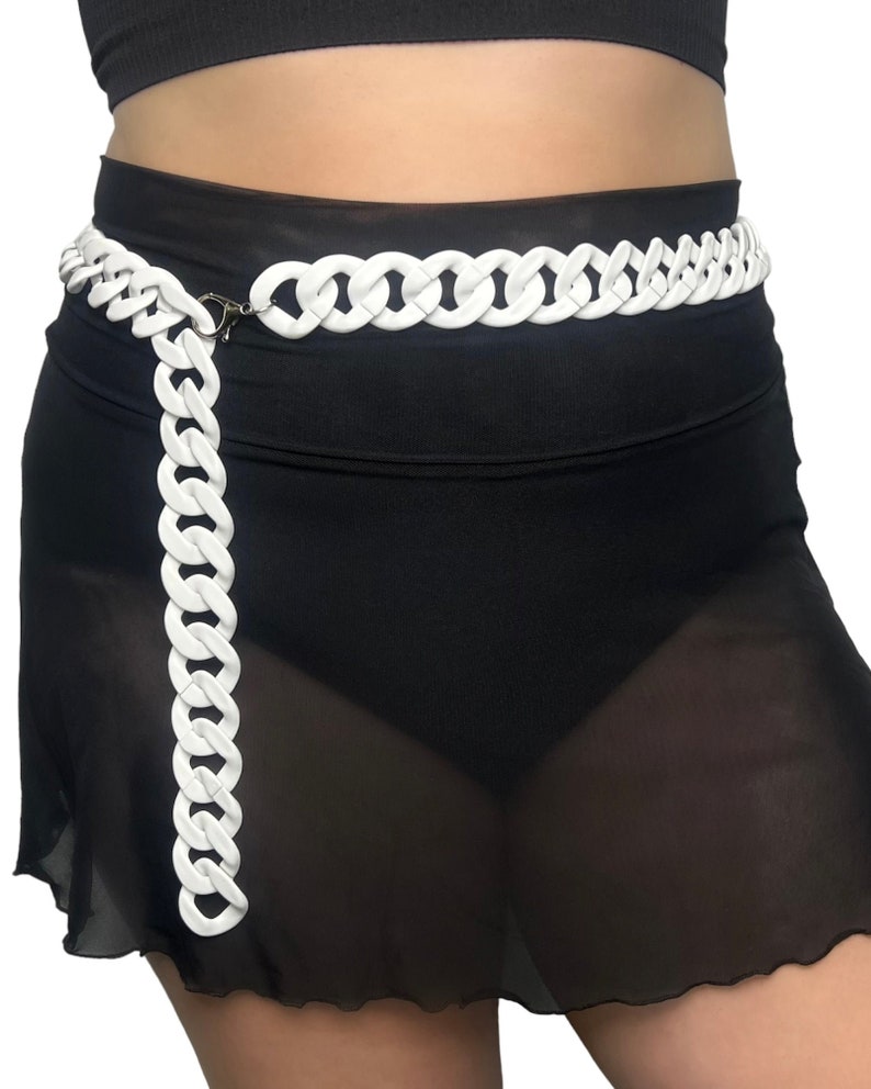 The model showcases a Colored Chunky Chain Belt in white, adding a stylish touch to her festival outfit.