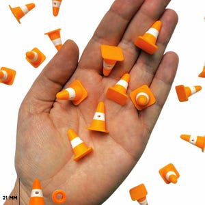 May include: Miniature orange traffic cones with white stripes and a white top are scattered across a hand. The cones are 21 mm tall and 14 mm wide. The image includes the text "ONE STOP RAVE".