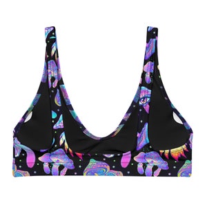 May include: Black bikini top with a vibrant, psychedelic mushroom and eye pattern. The design features colorful mushrooms, eyes, and stars in shades of purple, blue, and yellow. The top has a scoop neck and wide straps.