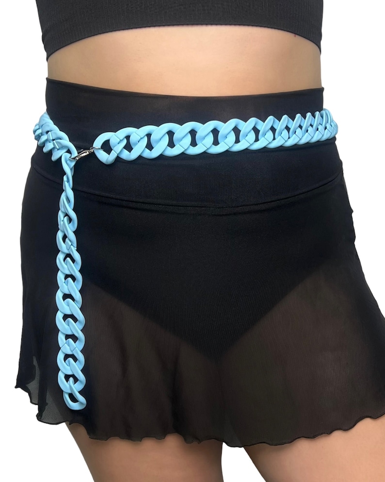 The model showcases a Colored Chunky Chain Belt in light blue, adding a stylish touch to her festival outfit.