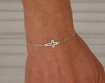 Pulsera con cruz de plata de ley y cadena ajustable.