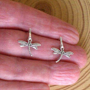 Op de afbeelding: Twee zilveren libellenbedels met een lus aan de bovenkant om aan sieraden of andere knutselwerkjes te bevestigen.