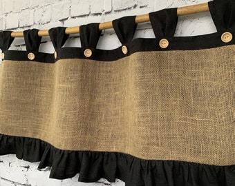 May include: A burlap valance with a black ruffle and wooden rod. The valance has four wooden buttons.