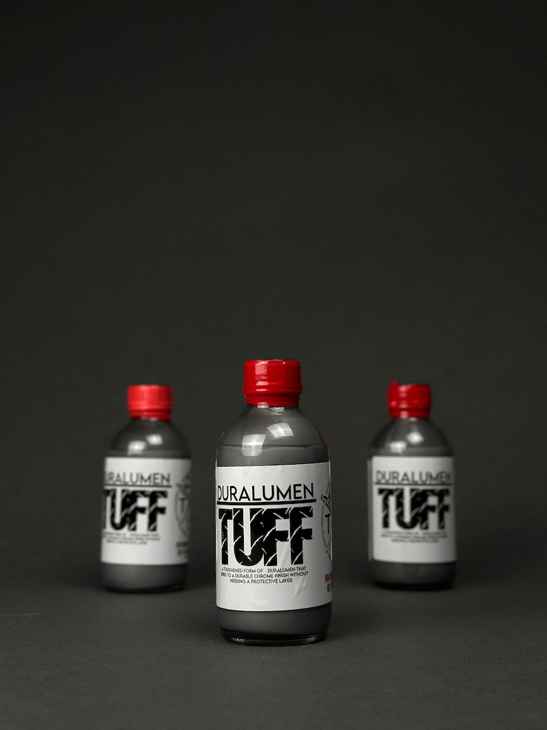 May include: Three bottles of Duralumen Tuff, a toughened form of Duralumen that creates a durable chrome finish without needing a protective layer. The bottles are silver with red caps and white labels.