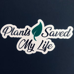 May include: White sticker with black text that reads "Plants Saved My Life" and a green leaf graphic.