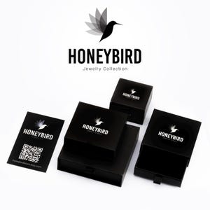 a collection of black jewelry boxes and business cards for a brand called "Honeybird Jewelry Collection".