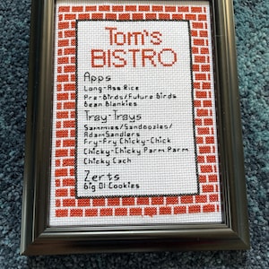 Parks and Rec Tom’s Bistro menu finished cross stitch