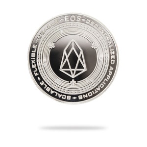 Puede incluir: Una moneda de plata con un centro negro que presenta un diseño geométrico y el texto "EOS Decentralized Applications Scalable Usable Flexible".