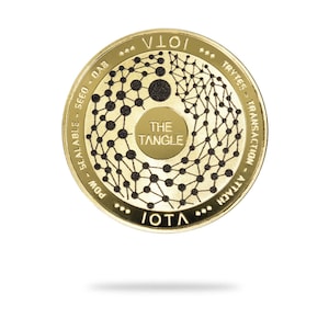 Puede incluir: Una moneda de color dorado con el texto "IOTA" y "THE TANGLE" en ella. La moneda tiene un diseño en blanco y negro de una red de puntos interconectados.